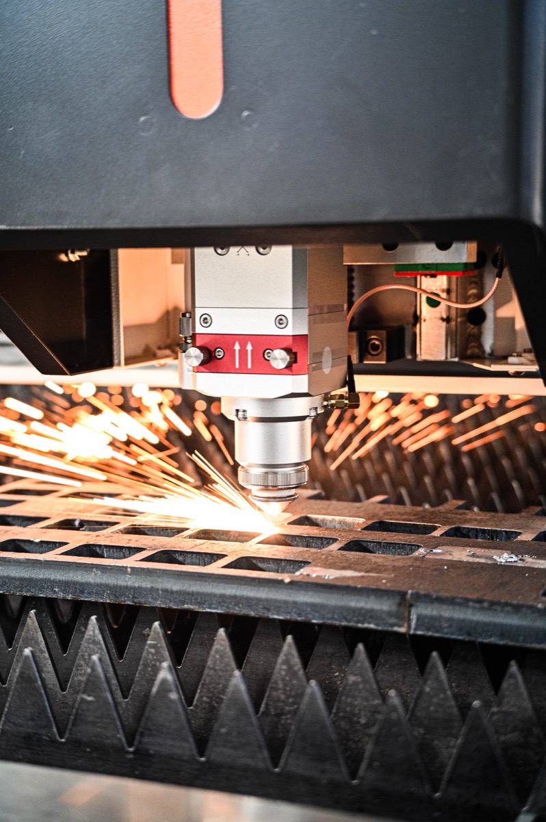 Close-up of a CNC fibre laser cutting head in action