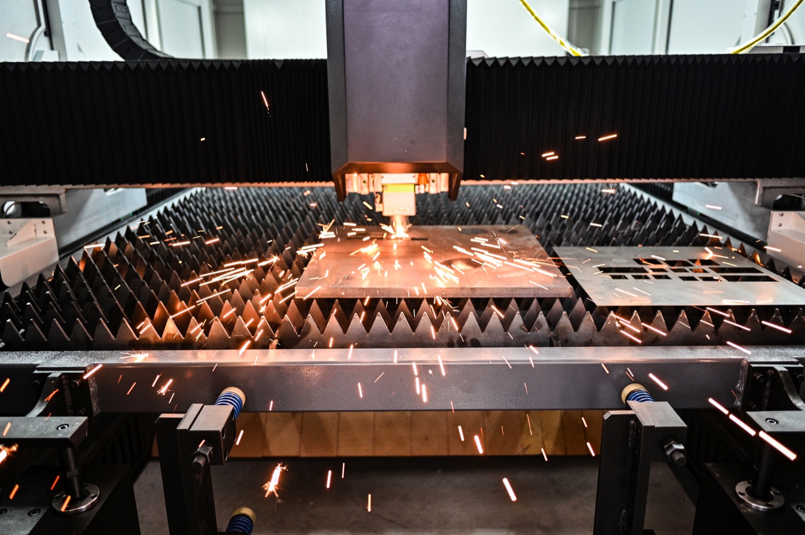 CNC fibre laser cutting metal plate with sparks